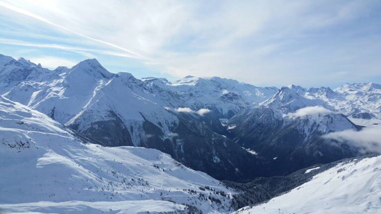 Snow-covered mountain range under a blue sky